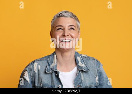Positive Emotionen. Nahaufnahme von glücklich stilvoll reifen Frau suchen weg und lachen Stockfoto