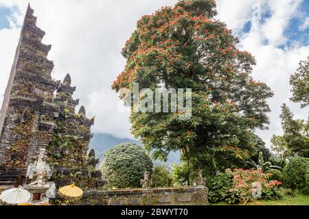 Traditionelle balinesische Split Gates Candi bentar. Bedugul, Gianyar, Bali, Indonesien. Erythrina variegata oder Tigerklaue oder indische Korallenbäume um. Stockfoto