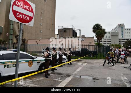 MIAMI, FL – Juni 02: Polizeibeamte aus Miami-Dade beobachten, wie Demonstranten vorbeigehen, während Demonstranten Schilder halten und marschieren, während sie den Verkehr gegen Polizeibrutalität und den jüngsten Tod von George Floyd vor der Staatsanwaltschaft für Miami-Dade County im Büro Katherine Fernandez Rundle in Florida abschalten. Wynwood District und Overtown Historic District am 02. Juni 2020 in Miami, Florida. Proteste werden weiterhin in allen 50 Staaten und Städten im ganzen Land über den Tod von George Floyd, der während der Polizeigewahrsam in Minneapolis am 25. Mai getötet wurde, gehalten. Kredit: MPI10/ME Stockfoto