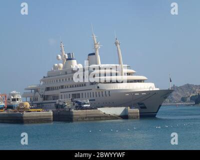 Ein Schiff legt am Hafen an. Muscat, Omans Hafenhauptstadt, liegt am Golf von Oman, umgeben von Bergen und Wüste. Oman, offiziell das Sultanat Oman, ist ein Land an der südöstlichen Küste der Arabischen Halbinsel in Westasien. Die Geschichte reicht bis in die Antike zurück und verbindet Hochhäuser mit gehobenem Shopping. Stockfoto