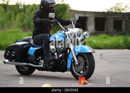 25-05-2020 Riga, Lettland. Motorradfahrer fährt auf Straße, Seitenansicht, Nahaufnahme. Stockfoto
