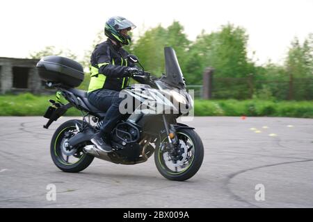 25-05-2020 Riga, Lettland. Motorradfahrer fährt auf Straße, Seitenansicht, Nahaufnahme. Stockfoto