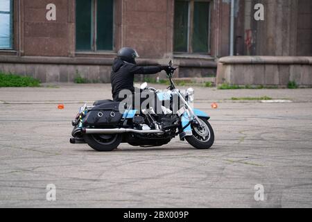 25-05-2020 Riga, Lettland. Motorradfahrer fährt auf Straße, Seitenansicht, Nahaufnahme. Stockfoto