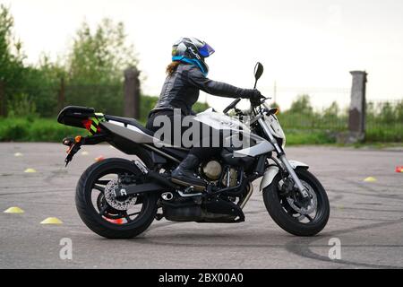 25-05-2020 Riga, Lettland. Motorradfahrer fährt auf Straße, Seitenansicht, Nahaufnahme. Stockfoto
