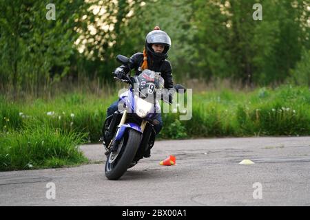 25-05-2020 Riga, Lettland. Motorradfahrer fährt auf Straße, Seitenansicht, Nahaufnahme. Stockfoto
