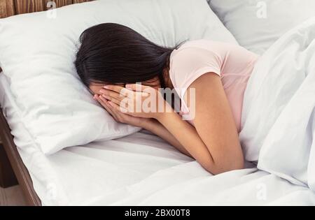 Unerkennbares Mädchen Weinend Gesicht Mit Händen Im Bett Liegend Stockfoto