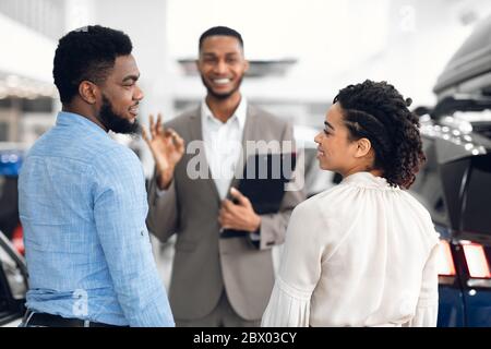 Afroamerikanisches Paar Beratung Mit Verkäufer Kauf Auto In Showroom Stockfoto