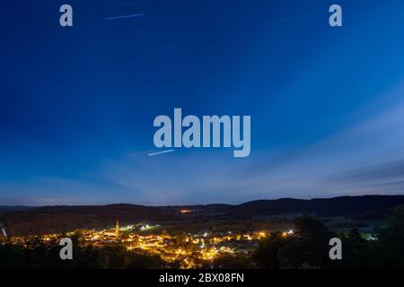 Sternspuren über die Stadt Zell in Deutschland, Bayern, Oberpfalz bei Nacht mit Sternenhimmel und Wolken Stockfoto