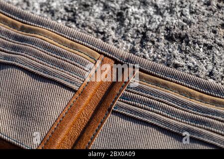 Kartenhalter genäht und von Hand geschnitten in handgefertigten Brieftasche aus braunem Leder und kariertem Textil auf Steingrund. Stockfoto