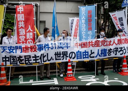 Tokio, Japan. Juni 2020. Während der Demonstration halten die Demonstranten Banner mit Gesichtsmasken.Pro-Demokratische Gruppen protestieren vor der chinesischen Botschaft in Japan, um den 31. Jahrestag des Massakers auf dem Platz des Himmlischen Friedens zu begehen. Quelle: SOPA Images Limited/Alamy Live News Stockfoto