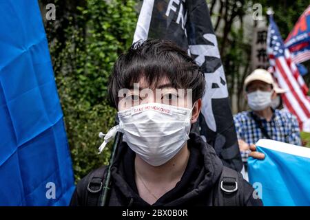 Tokio, Japan. Juni 2020. Ein Protestler schaut während der Demonstration mit einer Gesichtsmaske zu.Pro-Demokratische Gruppen protestieren vor der chinesischen Botschaft in Japan, um den 31. Jahrestag des Massakers auf dem Platz des Himmlischen Friedens zu begehen. Quelle: SOPA Images Limited/Alamy Live News Stockfoto