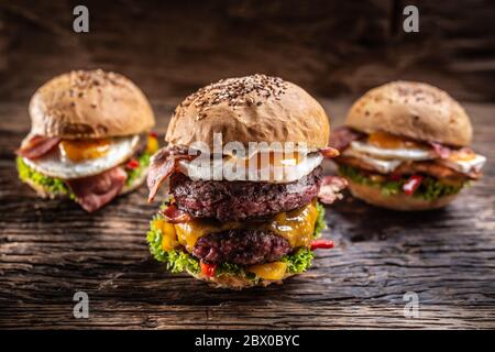 Menüauswahl mit verschiedenen frischen Burgern auf Holzoberfläche Stockfoto