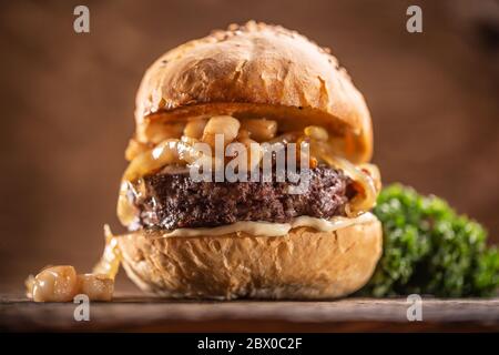 Rinderburger mit geschmolzenem Käse, karamellisierte Zwiebeln in einem Sesambrötchen Stockfoto