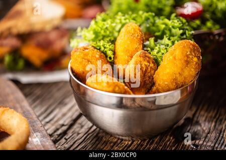 Hühnchen Nuggets mit Salat in einer Metallschüssel auf einer rustikalen Holzoberfläche Stockfoto