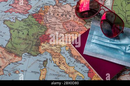 Rote Sonnenbrille, eine blaue OP-Maske und ein Pass auf einer Europakarte. Konzept des Urlaubs nach der COVID-19 Pandemie im Jahr 2020 Stockfoto