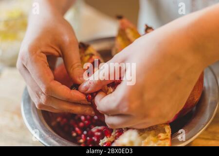 Amateur Cuisine - Nahaufnahme weibliche Hände hacken Granatapfel Stockfoto