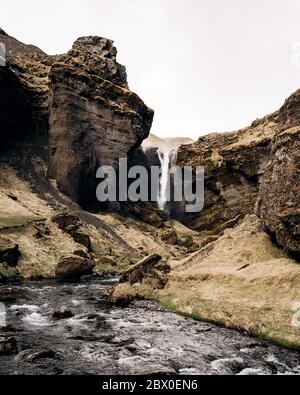 Die Straße zum Kvernufoss Wasserfall im Süden Islands, am Goldenen Ring. Gebirgsfluss in einer Schlucht mit Moos und gelbem Gras. Stockfoto