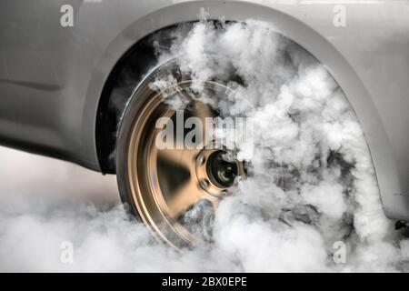 Ziehen Sie Rennwagen brennen Reifen an der Startlinie in Vorbereitung auf das Rennen Stockfoto