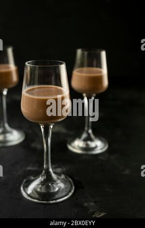 Selektiver Fokus: Schokolade und Kaffeelikör in einem hohen Stapel auf einem dunklen Tisch Stockfoto