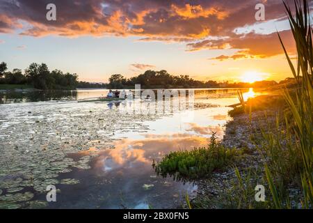 Das Ruderteam von Funce rudert bei Sonnenuntergang am Jarun See in Zagreb Stockfoto