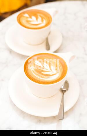 Cappuccino auf dem weißen Marmortisch in einem modernen Café. Auszeit, Kaffee, Luxus, Freunde Meeting Konzept. Platz für Text Stockfoto