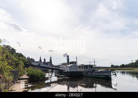 03. Juni 2020, Sachsen, Dresden: Ein historischer Raddampfer der Sächsischen Dampfschiffahrt wird an einer Anlegestelle am Terrassenufer festgemacht. Die Sächsische Dampfschiffahrt Dresden (SDS) hat Insolvenz angemeldet. Hintergrund sind finanzielle Schwierigkeiten, für die die SDS letzte Woche die fehlende Tranche eines Darlehens des Freistaates verantwortlich machte. Die 'Weiße Flotte' arbeitet mit neun Raddampfern, die zwischen 1879 und 1929 gebaut wurden, sowie zwei modernen Passagierschiffen und gilt als die älteste und größte Raddampfer-Flotte der Welt. Foto: Robert Michael/dpa-Zentralbild/dpa Stockfoto