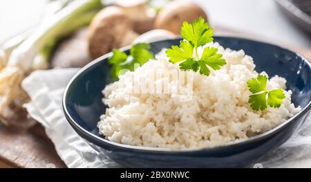 Schüssel mit gedämpftem Reis mit Pilzen und Lecks im Hintergrund Stockfoto