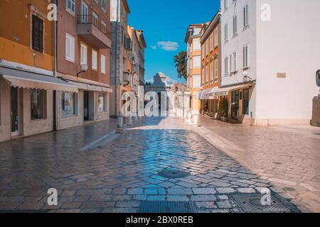 Zadar, Kroatien - Juli 24 2018: Straßen in der Altstadt von Zadar. Das berühmte Meertor zum Yachthafen im Hintergrund Stockfoto