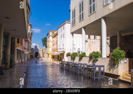 Zadar, Kroatien - Juli 24 2018: Straßen in der Altstadt von Zadar. Das berühmte Meertor zum Yachthafen im Hintergrund Stockfoto