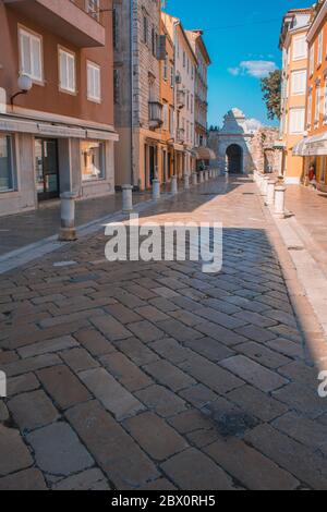 Zadar, Kroatien - Juli 24 2018: Straßen in der Altstadt von Zadar. Das berühmte Meertor zum Yachthafen im Hintergrund Stockfoto