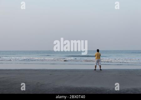 Mann am Strand Blick auf das Meer, Shrivardhan Strand, Shrivardhan, Maharashtra, Indien Stockfoto