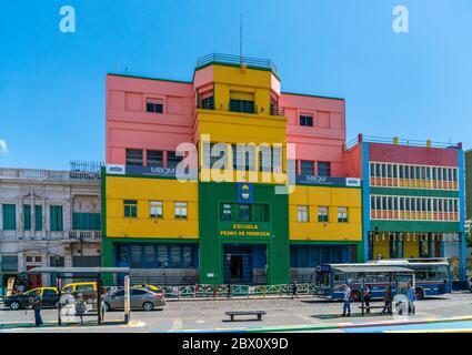 Touristen besuchen die berühmten farbigen Häuser in La Boca vor der Escuela Pedro de Mendoza (Schule), La Boca, Buenos Aires, Argentinien - Januar Stockfoto