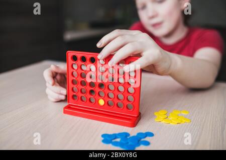 Rothaariger englischer Junge spielt ein Brettspiel - vier in einer Reihe Stockfoto