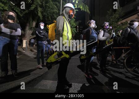 Portland, USA. Juni 2020. Demonstranten halten Laubbläser, um Tränengas zu löschen, wenn sie am 4. Juni 2020 nach dem Tod von George Floyd in Polizeigewahrsam in der sechsten Nacht der Aktion gegen Polizeibrutalität in Portland, Oregon, eingesetzt werden. (Foto: Alex Milan Tracy/Sipa USA) Quelle: SIPA USA/Alamy Live News Stockfoto