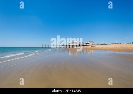 Der Pier und Sandstrand am Meer bei Bognor Regis, einem Küstenort in West Sussex, Südküste Englands an einem sonnigen Tag mit blauem Himmel Stockfoto