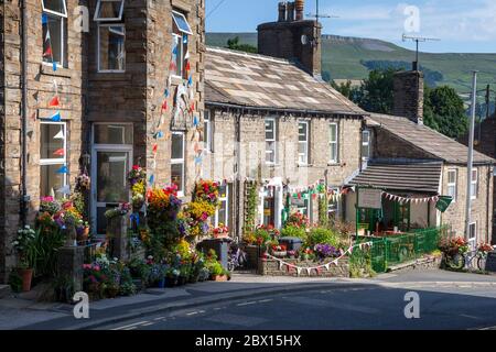 Farbenfrohe Blumenpracht in Töpfen im Zentrum der Stadt Hawes in Yorkshire Dales Stockfoto