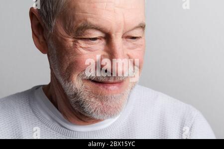 Porträt eines glücklichen älteren Mannes mit Bart und Schnurrbart in einem Atelier. Stockfoto