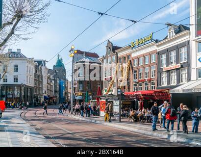 Amsterdam, 9. april 2019 - Touristen warten auf eine Straßenbahn auf dem Remabrandtplatz in der Altstadt Stockfoto