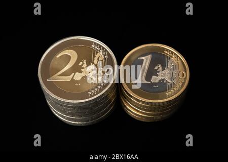 Stapel von zwei und einer Euro-Münzen auf schwarzem Hintergrund isoliert Stockfoto