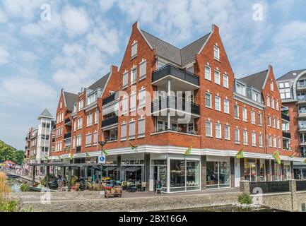 Groesbeek, Niederlande 19. Juli 2018 - Menschen genießen einen Drink und Essen vor einem modernen Gebäude mit Restaurant und Geschäften Stockfoto