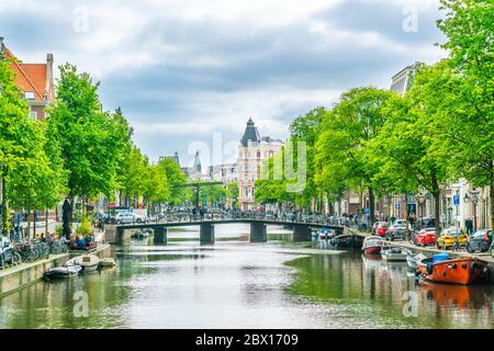 Amsterdam Mai 18 2018 - der Kloveniersburgwal Kanal mit im Hintergrund Brücken und die Altstadt von Amsterdam Stockfoto