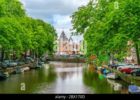 Amsterdam Mai 18 2018 - Kloveniersburgwal Kanal mit im Hintergrund der Nieuwmarkt Platz und das alte Waagh Gebäude (Scale House) Stockfoto