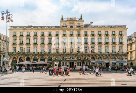 Bordeaux, Frankreich, 8. Mai 2018 - Touristen und Einheimische passieren das berühmte Grand Intercontinental Hotel auf dem 'Place de la Comedie' Stockfoto