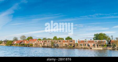Ouderkerk aan de Amstel, Niederlande, 19. April 2017: Reihe traditioneller holländischer Häuser am Flussufer des Amstelfluß Stockfoto