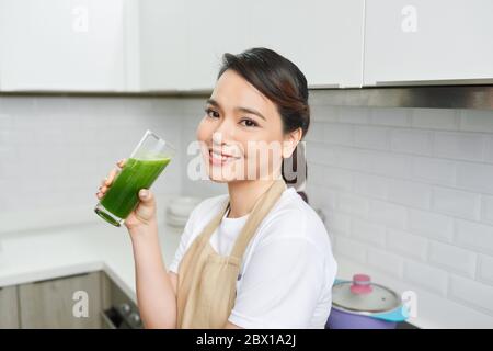 Entgiftungskonzept. Nahaufnahme Porträt von asiatischen Mädchen Glas mit hausgemachten grünen Saft, Blick beiseite auf freien Raum Stockfoto