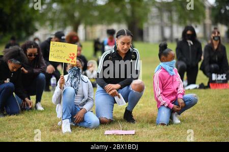 Die Menschen nehmen ein Knie für zwei Minuten während einer Black Lives Matter Protestkundgebung im Eastville Park in Bristol in Erinnerung an George Floyd, der am 25. Mai während in Polizeigewahrsam in der US-Stadt Minneapolis getötet wurde. Stockfoto