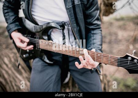 Nahaufnahme des Spiels schwarze E-Gitarre - Rock and Roll Stockfoto