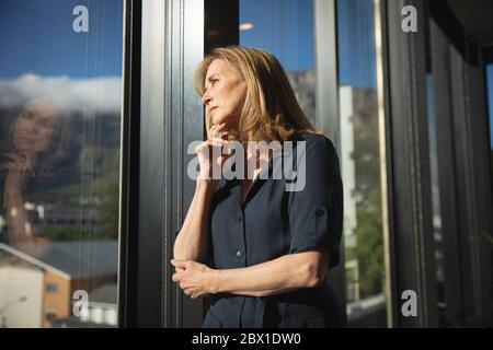 Kaukasische Geschäftsfrau nachdenklich und Blick nach draußen Stockfoto