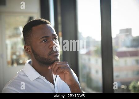 Afroamerikanischer Geschäftsmann nachdenklich und Blick nach draußen Stockfoto