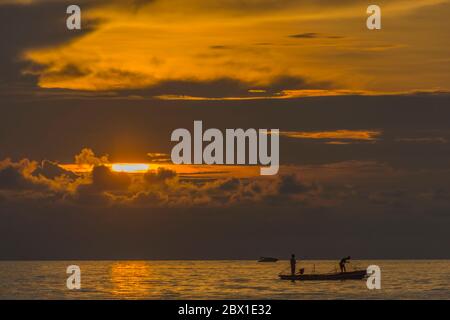 Fischer fischen bei Sonnenuntergang in einem kleinen Boot in der Nähe der Insel Bunaken. Nord-Sulawesi, Indonesien. Stockfoto